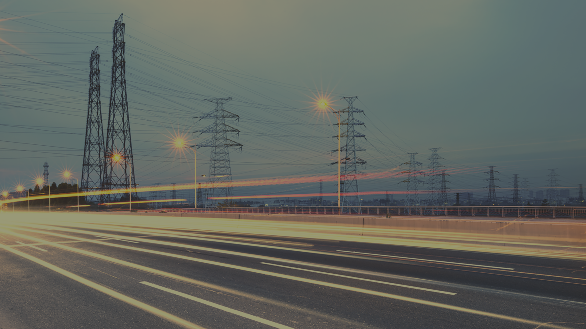 road with phone towers in background at dusk